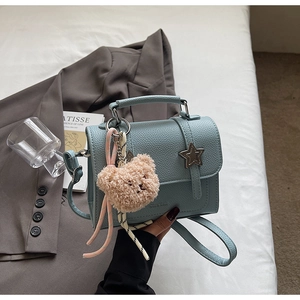 Close-up of a light blue lychee pattern leather crossbody bag with a silver star clasp