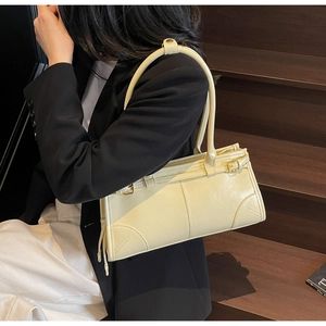 Model wearing a cream yellow pleated underarm bag in a vintage minimalist design
