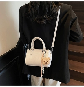 Close-up of white lychee pattern Boston bag with cute teddy bear and silk ribbon detail
