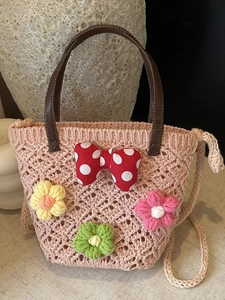 Pink hand-woven floral tote bag with a polka dot bow and dark leather handles