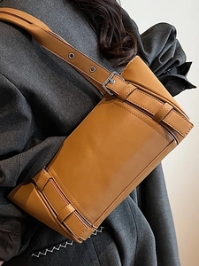 Sac sous le bras en cuir marron minimaliste avec œillets argentés sur la bandoulière