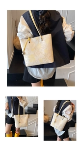 Detail view of cream bucket bag with yellow floral pattern and long leather straps