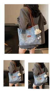 Detail of light blue floral canvas tote bag featuring brown woven leather shoulder straps
