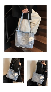 Detailed view of light blue tote bag with floral prints and braided rope handles