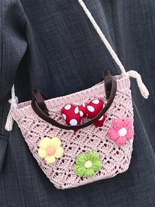 Pink hand-woven flower crochet crossbody bag with polka dot bow and leather handle