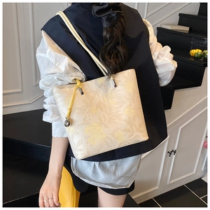 Detail of floral tote bag showing delicate yellow flower print and yellow fringe tassel