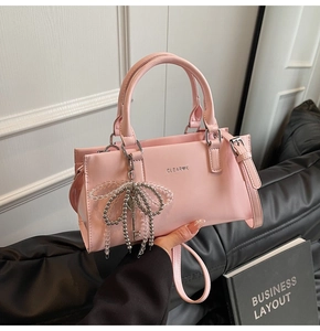 Detailed close-up of pink PU leather tote with beaded bow and silver key pendant charm
