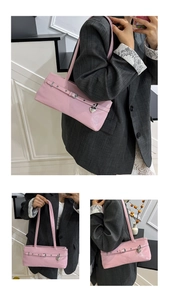 Detail of pink baguette underarm bag with silver heart pendant and glossy finish