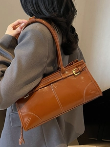 Retro brown glossy leather shoulder bag with buckle detail in classic bowling silhouette