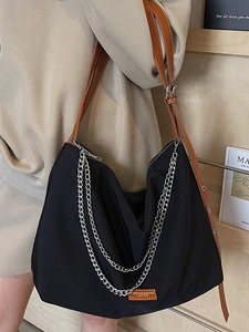 Minimalist black tote bag with silver chains and leather strap for women