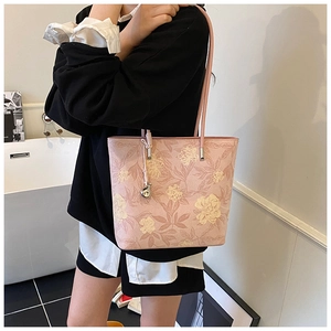 Detailed side view of pink floral bucket bag with refined embroidery and leather strap