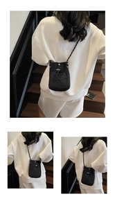 Detail view of mini nylon crossbody bag with drawstring closure and textured shoulder strap