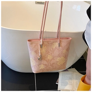 Detail of pink floral canvas bucket bag with yellow peonies and silver ball charm