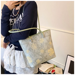 Detail of mint green tote bag with vintage floral pattern and slim shoulder handles