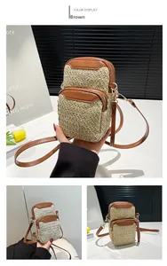 Detail of woven straw phone bag with brown leather trim and front zipper pocket
