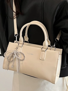 Minimalist beige PU leather tote bag with top handles and beaded bow charm accessory