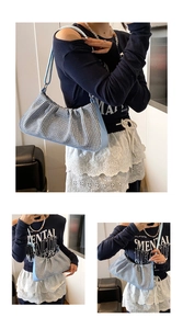 Detail of blue and white textured fabric on pleated cloud bag with leather strap