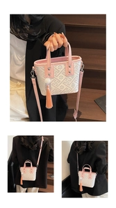 Close-up of pink and beige bucket bag with embroidery, tassel charm and silver hardware