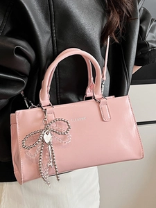 Pink minimalist tote bag with beaded bow pendant and silver metallic hardware detailing
