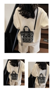 Detail showing the mini tote bag with geometric floral pattern and long fringe tassel charm