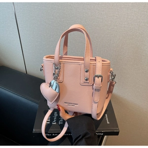 Pink lychee grain leather bucket bag with silver heart charm and adjustable strap
