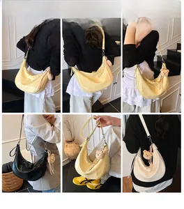 Chic dumpling-style underarm bag in yellow, black, and beige with bear charm details