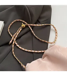 Detail of light pink leather braided chain strap with golden quilted ball slider adjuster
