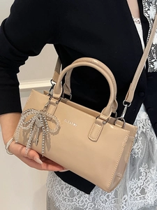 Elegant beige glossy faux leather tote bag with silver CLEAR K logo and bead bow accessory