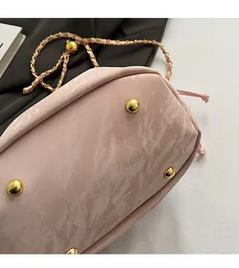 Detail shot of the pink pearl shoulder bag base featuring four golden protective studs