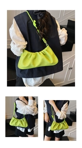 Detail of neon green woven crossbody bag with stylish knot strap and textured finish