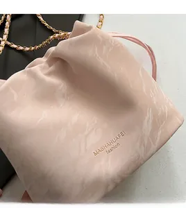 Detail of pink marble textured bucket bag with metal chain strap and logo finish