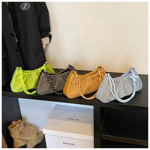 Detail showing various pleated underarm bags in multiple colors and textures on a display