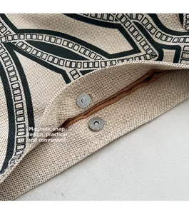 Detail of the magnetic metal buckle and woven texture on a beige tote bag