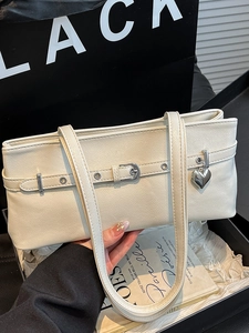 Minimalist cream underarm bag with silver heart pendant and stylish buckle strap detail