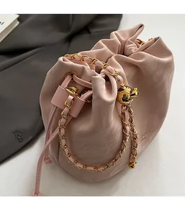 Detail of pink drawstring bucket bag with marble texture and gold chain strap