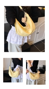 Detail of light yellow crocodile texture hobo bag with cute plush bear keychain