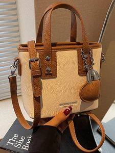 Fashionable beige and brown contrast bucket bag with dual handles and crossbody strap