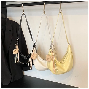 Detailed view of hobo bag textures in three colors with cute bear charms and braided straps