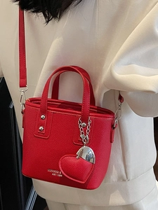 Fashionable red litchi grain bucket bag with heart pendant and silver hardware