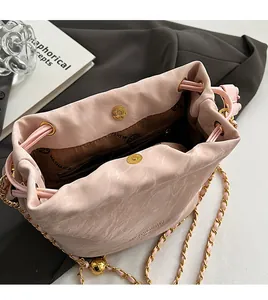 Detail view of pink marble bucket bag interior with drawstring and gold chain strap