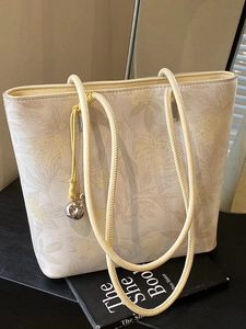 Elegant off-white floral bucket bag with thin straps and metallic spherical charm detail