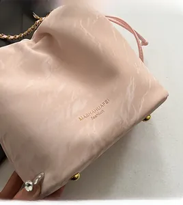Detailed close-up of pink marble pattern bucket bag with golden chain and metal studs