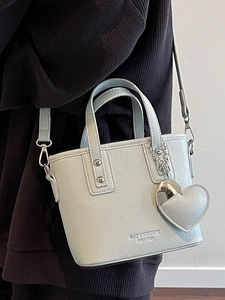 Fashionable light blue bucket bag with leather heart charm and adjustable shoulder strap