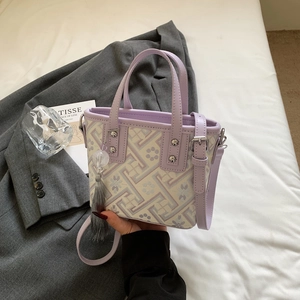 Detail of light purple bucket bag with Chinese floral embroidery and grey tassel accent