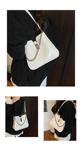 Details der weißen Leder-Schultertasche mit Silberverschluss und Metallkette am Gurt