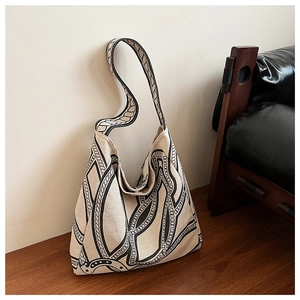 Detailed close-up of large canvas tote bag with artistic black rope patterns on beige