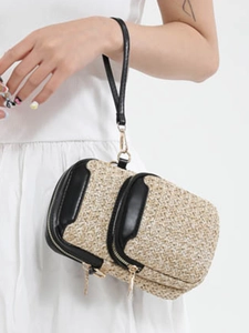 Artistic woven straw crossbody bag with black leather trim and wide shoulder strap
