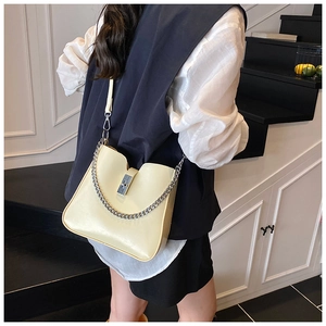 Detailansicht der cremefarbenen Ledertasche mit Silberverschluss und Metallkette
