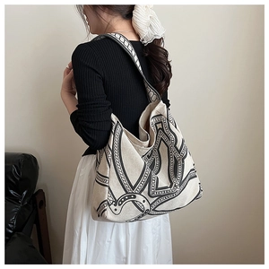 Detailed shot of large canvas tote bag with black chain print on a shoulder strap