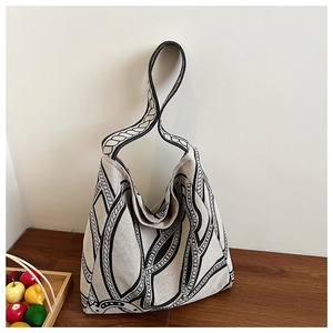 Detail of the geometric chain print on the minimalist beige canvas tote bag material